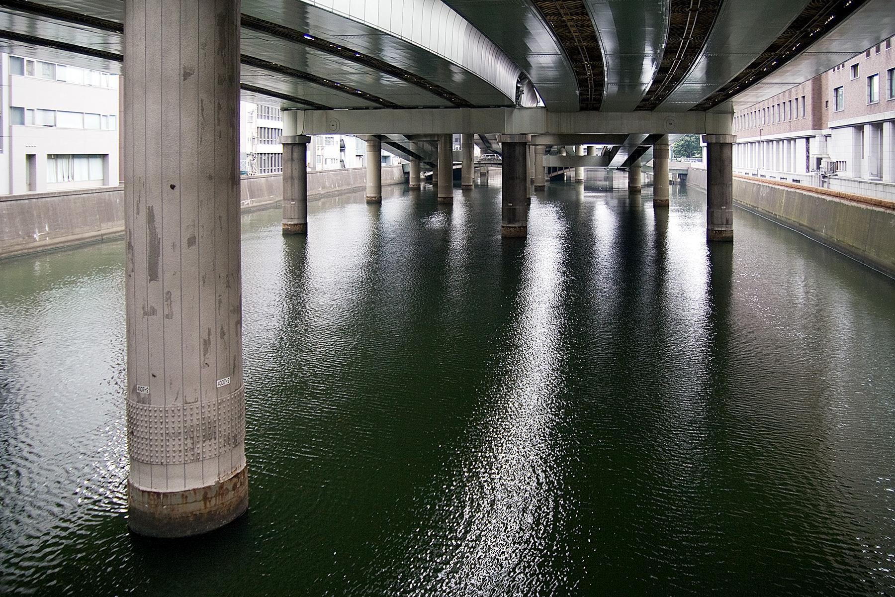 Autostraßenpfeiler im Fluss in Tokyo