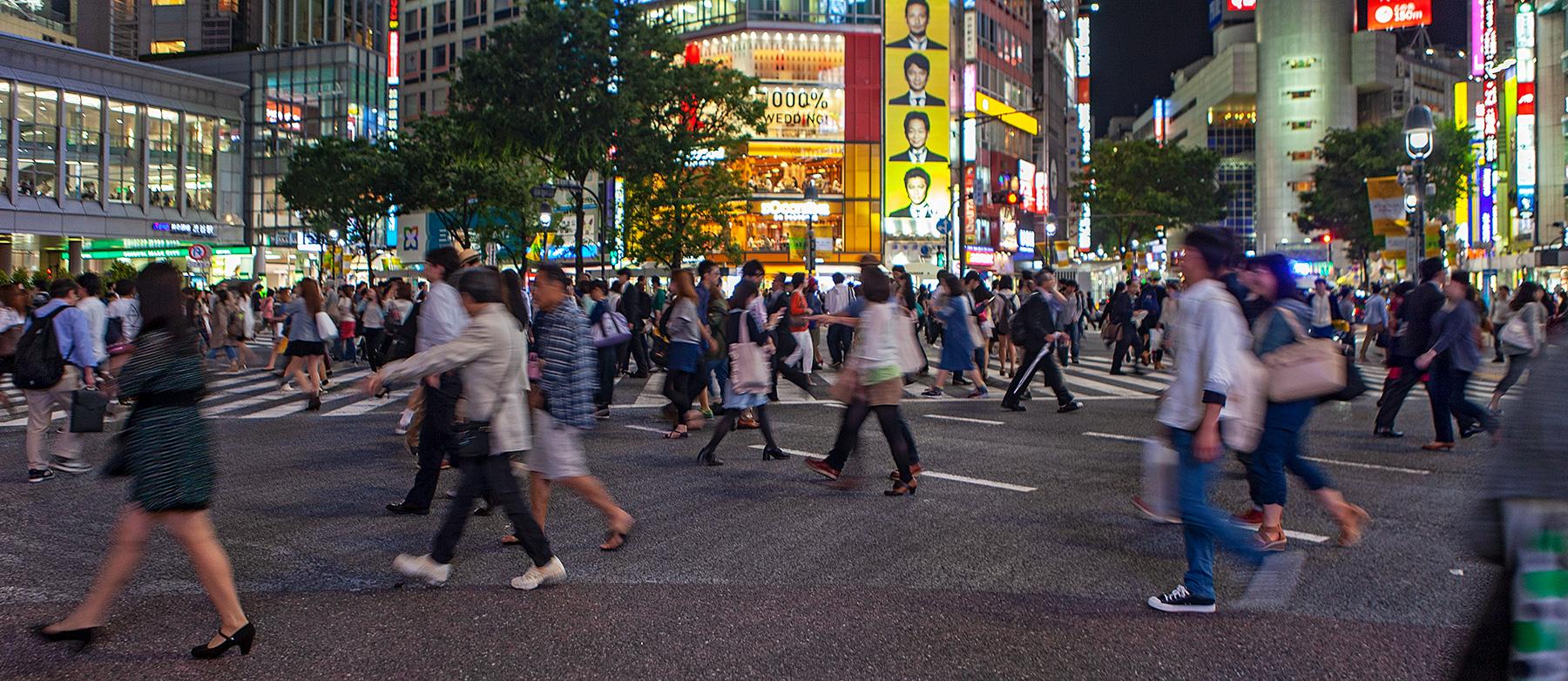 Fußgänger kreuzen die Straße am Abend in Tokyo