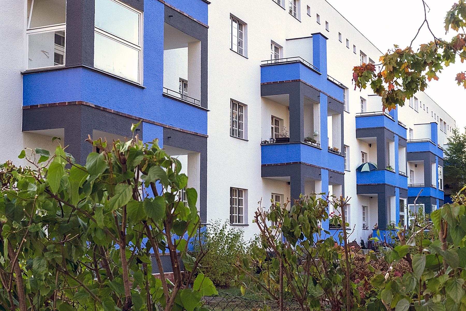 Hausfassade mit blauen Balkonen in der Siedlung des UNESCO Welterbes