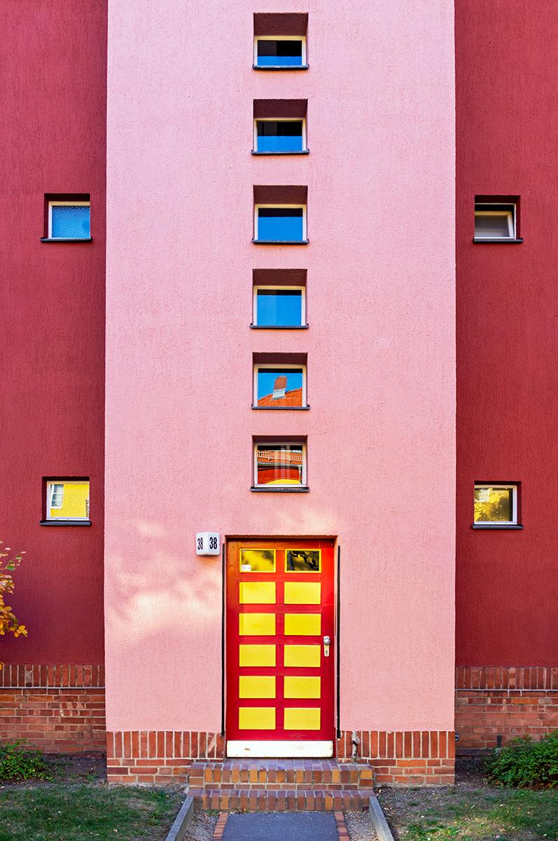 Eingangstür und Treppenhausfenster im roten Haus im Beitrag Berlin: Hufeisen Siedlung