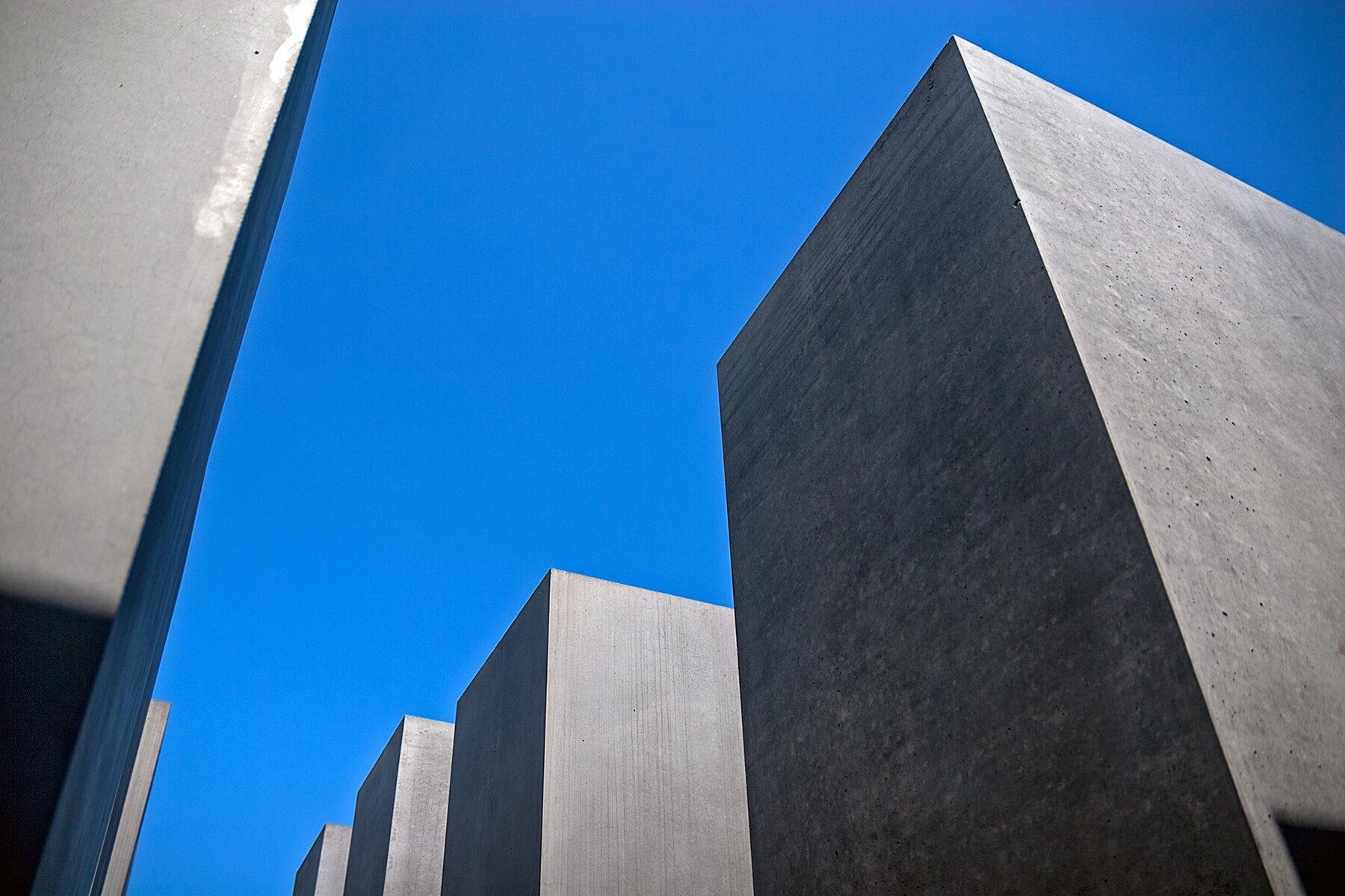Steelen auf dem Holocaust Mahnmal in Berlin gegen den blauen Himmel fotografiert