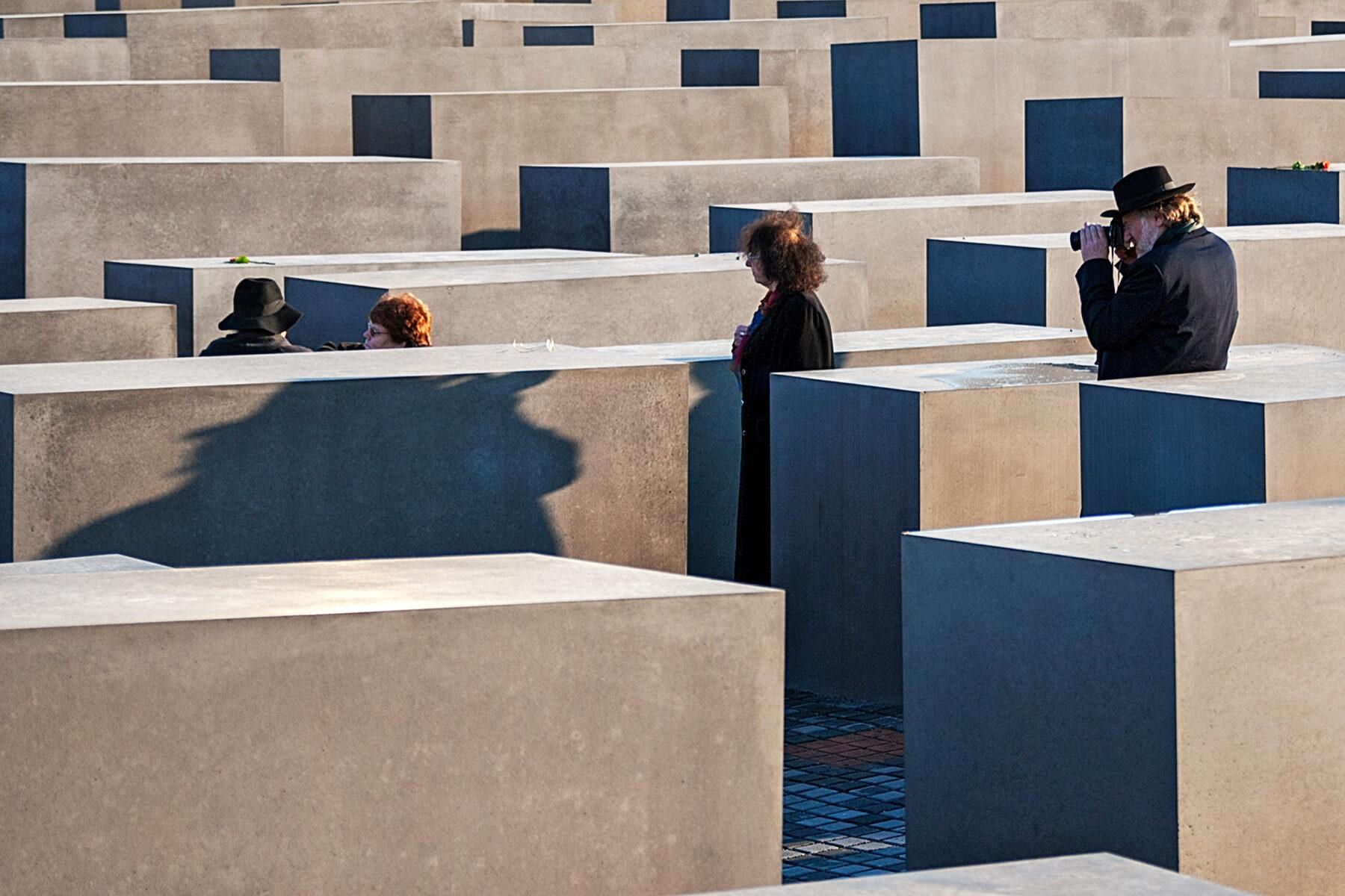Menschen fotografieren sich bei den Steelen auf dem Holocaust Mahnmal in Berlin