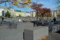 Herbstliche Bäume und Häuser bei den Steelen auf dem Holocaust Mahnmal in Berlin
