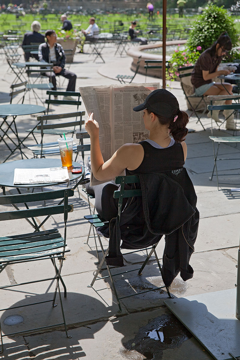 Frau, die Zeitung liest im Bryant Park, Manhattan auf der Seite Stadterkundung.com