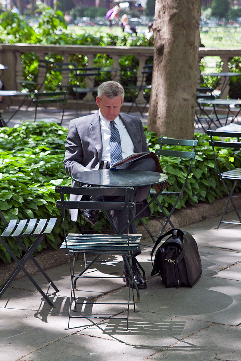 Büroangestellter liest im Bryant Park, Manhattan auf der Seite Stadterkundung.com