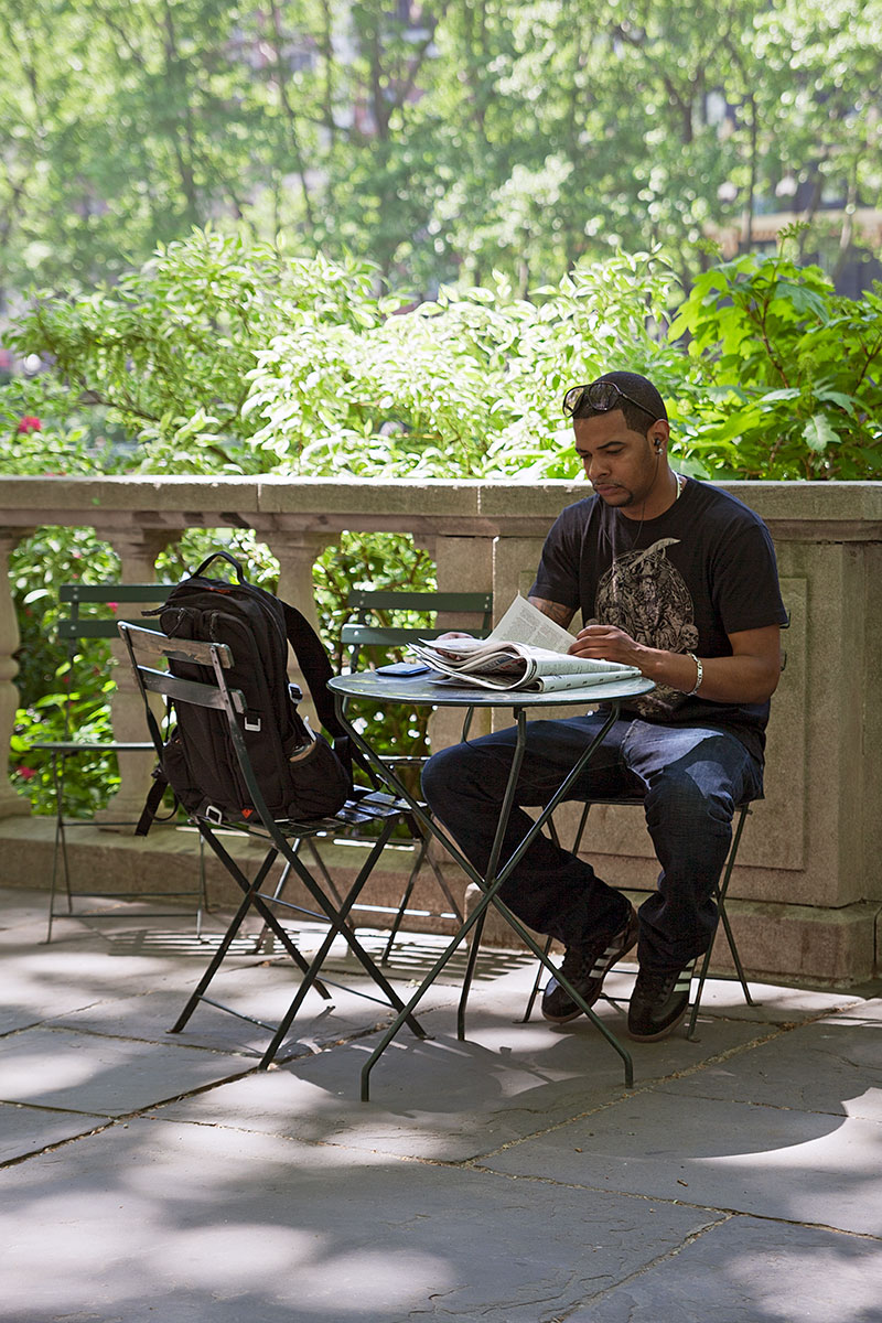 Mann, der Zeitung liest im Bryant Park, Manhattan auf der Seite Stadterkundung.com